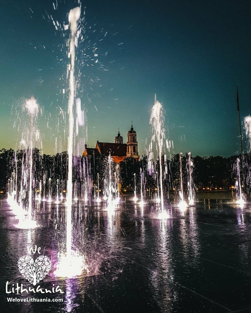 Atnaujintos Vilniaus Lukiškių aikštės pagrindinis akcentas - šokantis vandens purslų fontanas, vėlyvą vasaros vakarą.